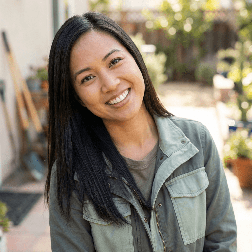 Female cleaning company founder in her early 30s, South Asian, warm and approachable demeanor, standing in a bright Toronto home with cleaning supplies nearby